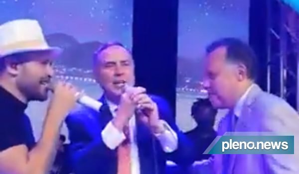 Sem máscara, Barroso canta e dança ao lado de Diogo Nogueira e jornalista da Globo