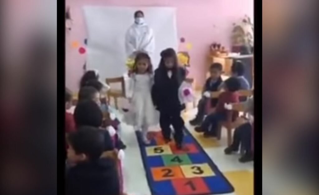 Professora casa duas meninas durante atividade na escola